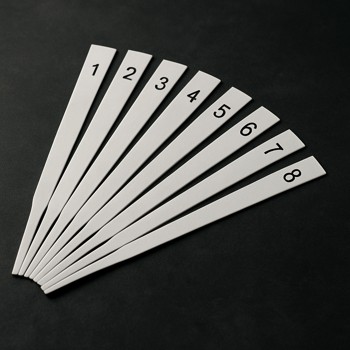 Fan of numbered scent strips laid out on a dark table