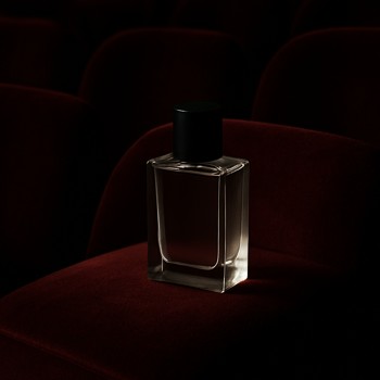Perfume bottle resting on velvet theatre seating