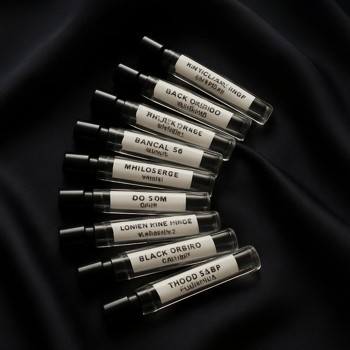 Fan of labelled perfume sample vials on a dark cloth